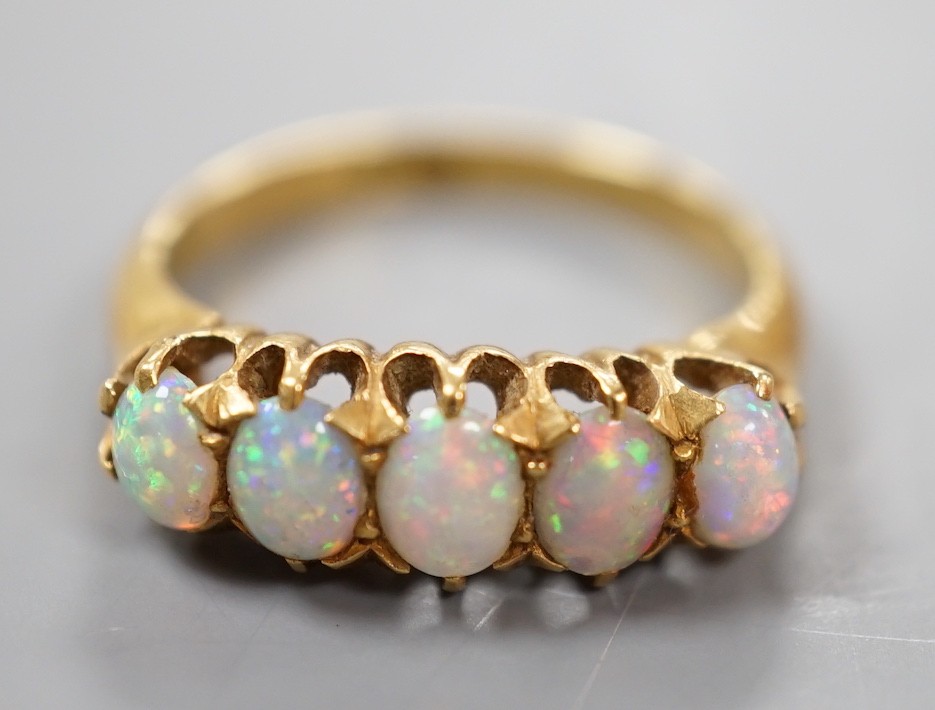 A 18ct and graduated five stone oval white opal set half hoop ring, size L, gross weight 3.8 grams.
